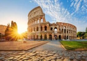 A view of the colosseum in rome at sunset.